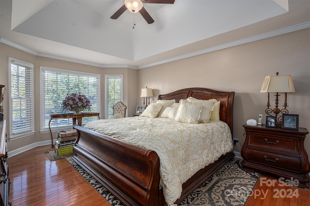 bedroom featuring ornamental molding, a raised ceiling, wood-type flooring, and ceiling fan