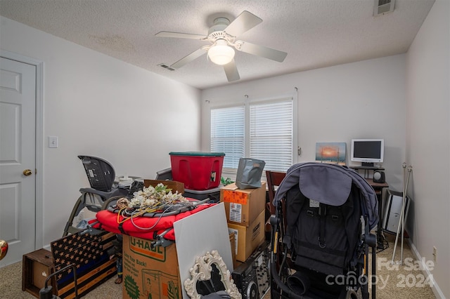 office with a textured ceiling, carpet floors, and ceiling fan