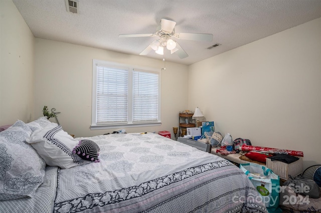 bedroom with a textured ceiling and ceiling fan