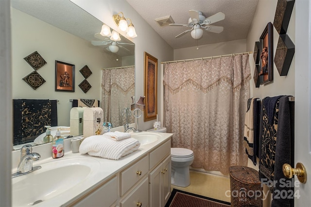 bathroom with toilet, curtained shower, vanity, a textured ceiling, and ceiling fan