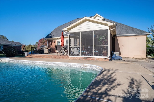 view of swimming pool featuring area for grilling, a patio area, and a sunroom