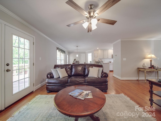 living room with light hardwood / wood-style floors, crown molding, a wealth of natural light, and ceiling fan