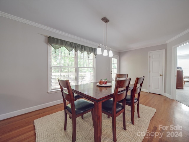 dining room with crown molding, light wood-type flooring, and plenty of natural light