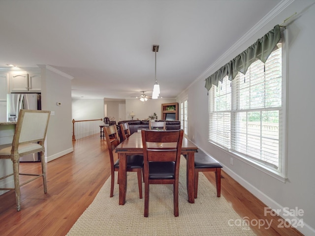 dining space featuring ceiling fan, ornamental molding, and light hardwood / wood-style flooring