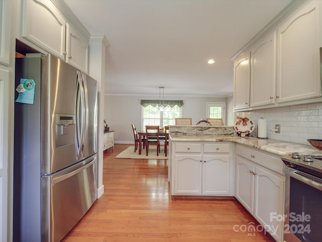 kitchen featuring kitchen peninsula, decorative light fixtures, light wood-type flooring, white cabinetry, and appliances with stainless steel finishes