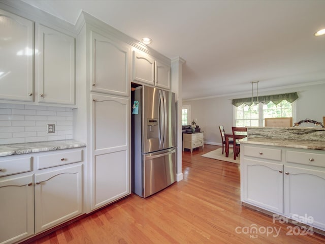 kitchen featuring light hardwood / wood-style floors, white cabinets, decorative light fixtures, and stainless steel fridge with ice dispenser