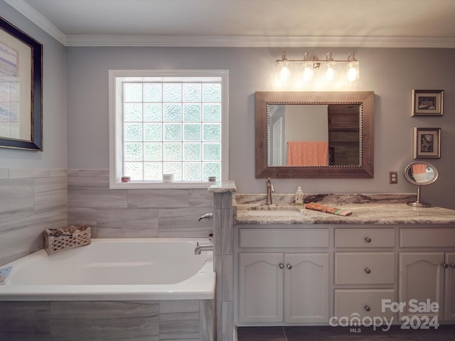 bathroom with vanity, crown molding, and tiled tub