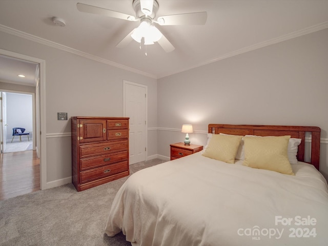 carpeted bedroom featuring ceiling fan and ornamental molding