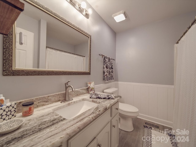 bathroom featuring vanity, toilet, and hardwood / wood-style flooring