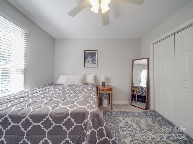 carpeted bedroom featuring a closet and ceiling fan