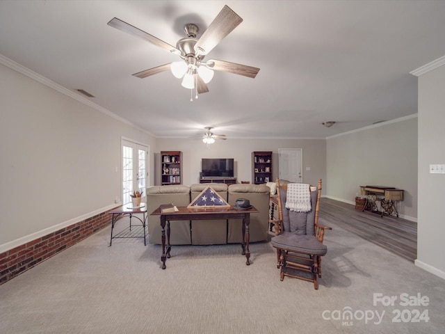 living room featuring brick wall, crown molding, carpet, and ceiling fan