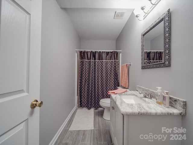 bathroom with vanity, toilet, hardwood / wood-style flooring, and a shower with curtain