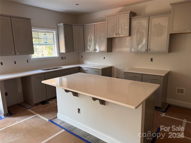 kitchen with gray cabinets, hardwood / wood-style floors, and a center island