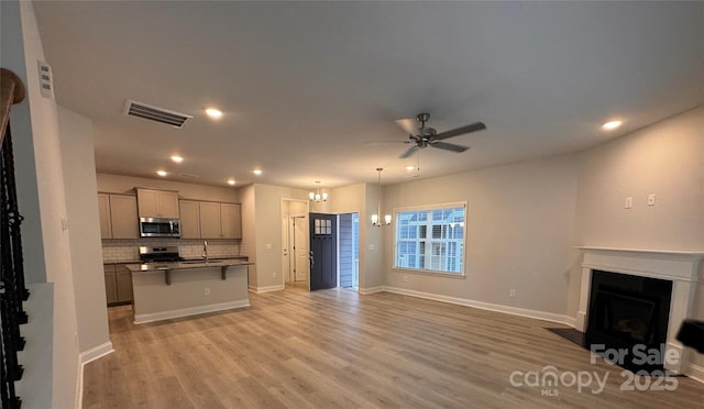 4049 Port Richmond Ave Unit 11, Gastonia, NC 28056 - unfurnished living room featuring ceiling fan with notable chandelier, visible vents, recessed lighting, light wood-style flooring, and a fireplace with flush hearth
