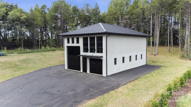 view of outdoor structure with a lawn and a garage