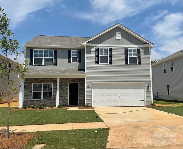 view of front of home with a garage and a front lawn