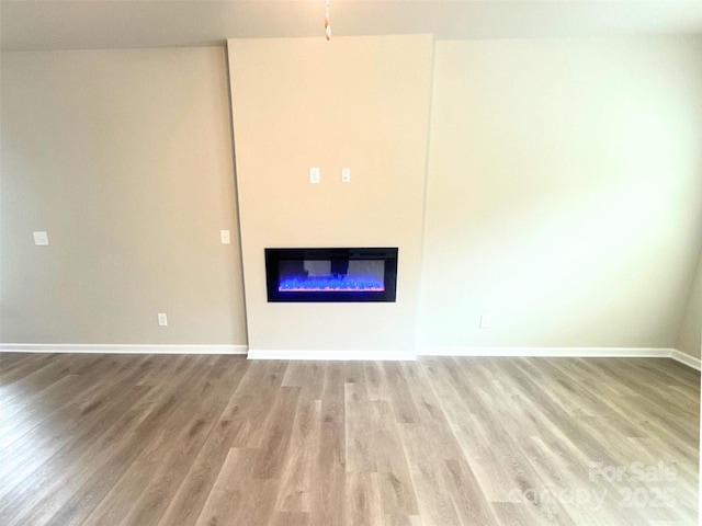 209 Lake George Dr, Shelby, NC 28152 - unfurnished living room with baseboards, a glass covered fireplace, and light wood-style floors