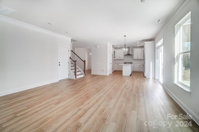 unfurnished living room featuring light hardwood / wood-style floors and ornamental molding