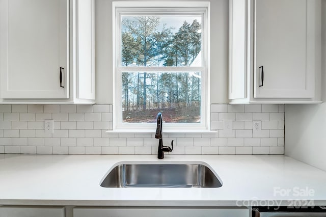 kitchen featuring white cabinets, decorative backsplash, plenty of natural light, and sink