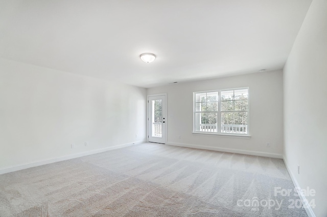 spare room featuring light colored carpet