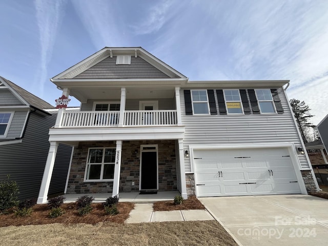 view of front of home with a balcony, a porch, and a garage