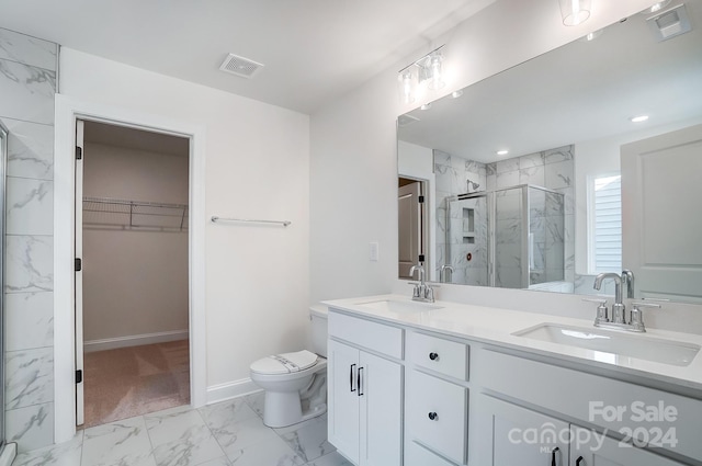 bathroom with a shower with door, vanity, and toilet