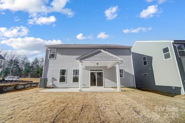 rear view of house with a lawn, a patio area, and central AC