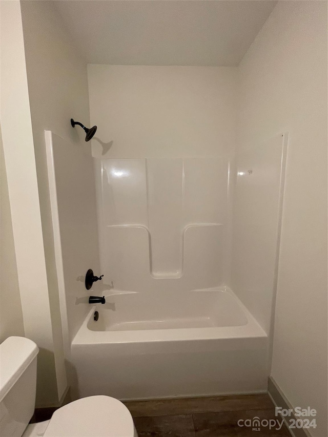 bathroom featuring toilet, tub / shower combination, and wood-type flooring