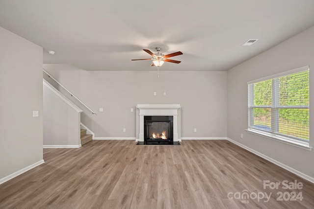 unfurnished living room with ceiling fan and light wood-type flooring