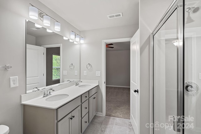 bathroom featuring ceiling fan, a shower with shower door, and vanity