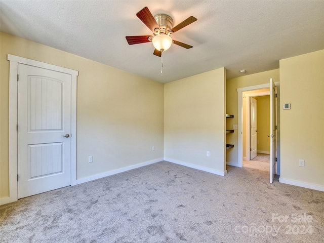 carpeted empty room featuring a textured ceiling and ceiling fan