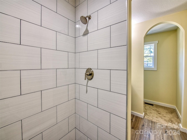 bathroom featuring a tile shower and hardwood / wood-style floors