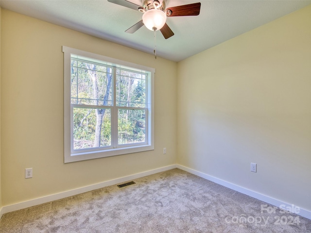 empty room featuring light colored carpet and ceiling fan