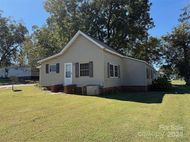 exterior space with a yard and central AC