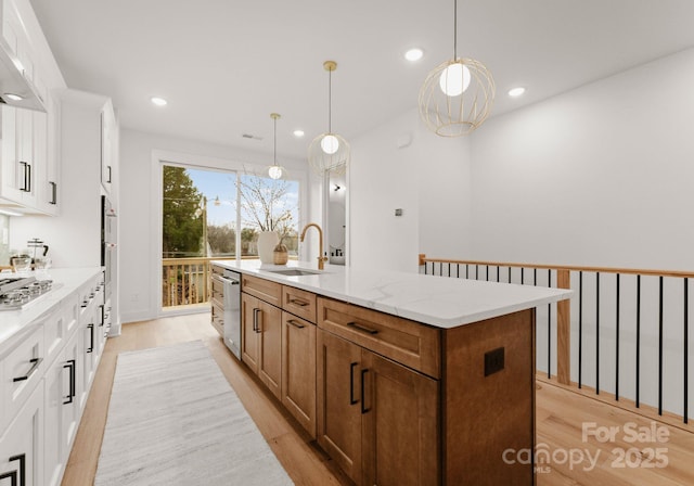 kitchen featuring sink, white cabinetry, and a kitchen island with sink