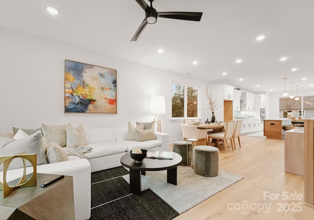 living room with ceiling fan and light hardwood / wood-style floors