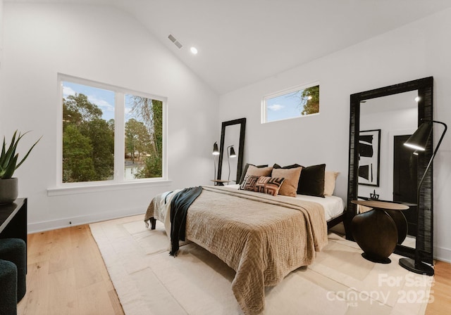 bedroom with vaulted ceiling and light wood-type flooring