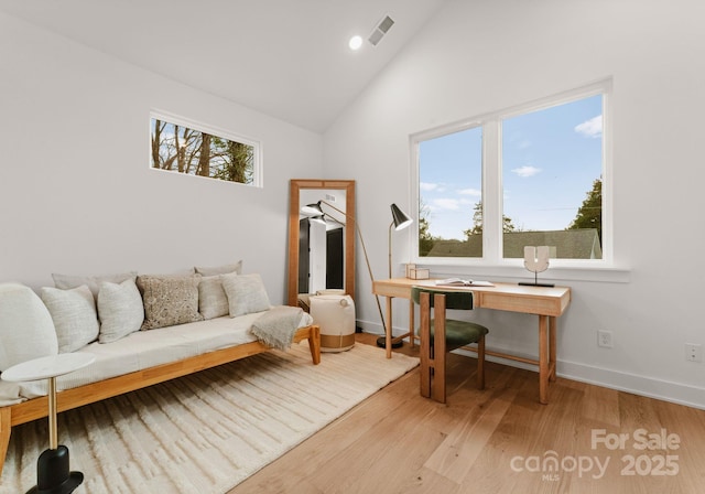 office featuring high vaulted ceiling and light hardwood / wood-style flooring