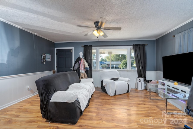 living room featuring crown molding, a textured ceiling, and light hardwood / wood-style floors