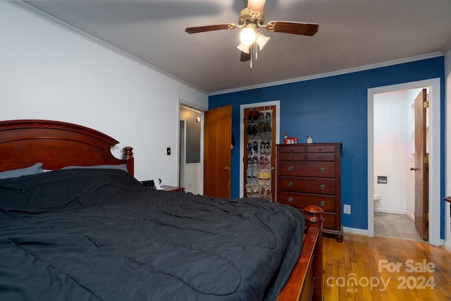 bedroom with crown molding, ceiling fan, light hardwood / wood-style floors, and ensuite bath