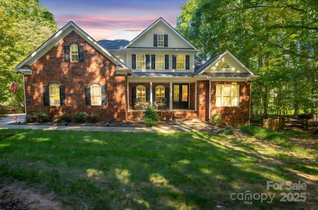 view of front of property with a lawn and a porch