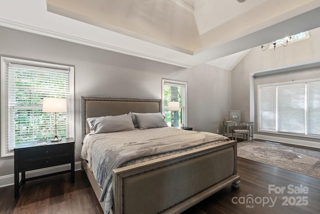 bedroom featuring vaulted ceiling, dark hardwood / wood-style floors, an inviting chandelier, and a tray ceiling