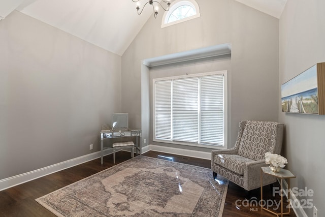 sitting room with high vaulted ceiling, dark hardwood / wood-style floors, and an inviting chandelier