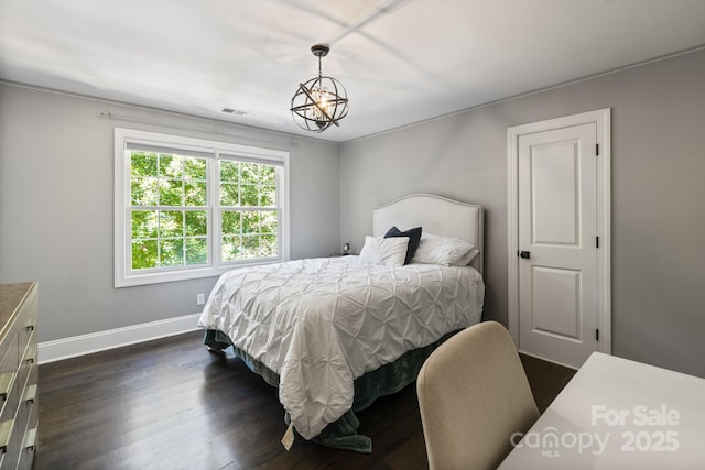 bedroom with a chandelier and dark hardwood / wood-style floors