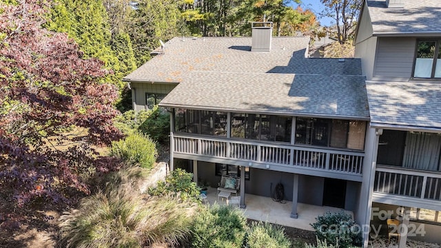 rear view of property with a patio area and a sunroom