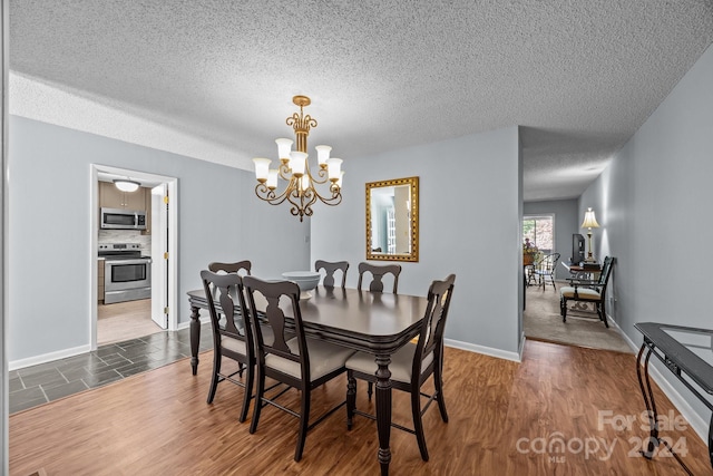 dining space featuring a notable chandelier, dark hardwood / wood-style floors, and a textured ceiling