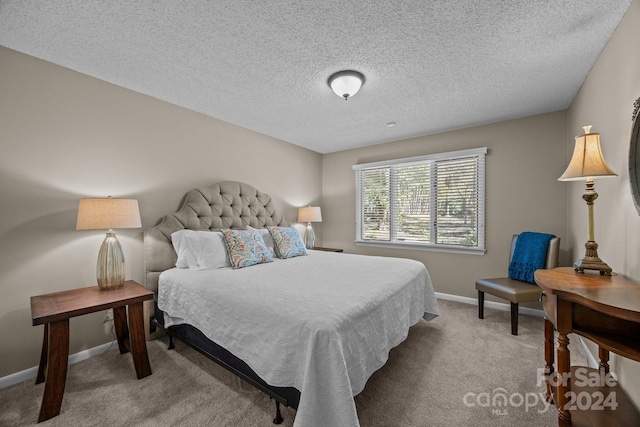 bedroom with a textured ceiling and light colored carpet