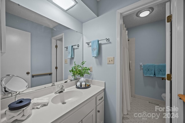 bathroom featuring a textured ceiling, toilet, vanity, curtained shower, and tile patterned floors