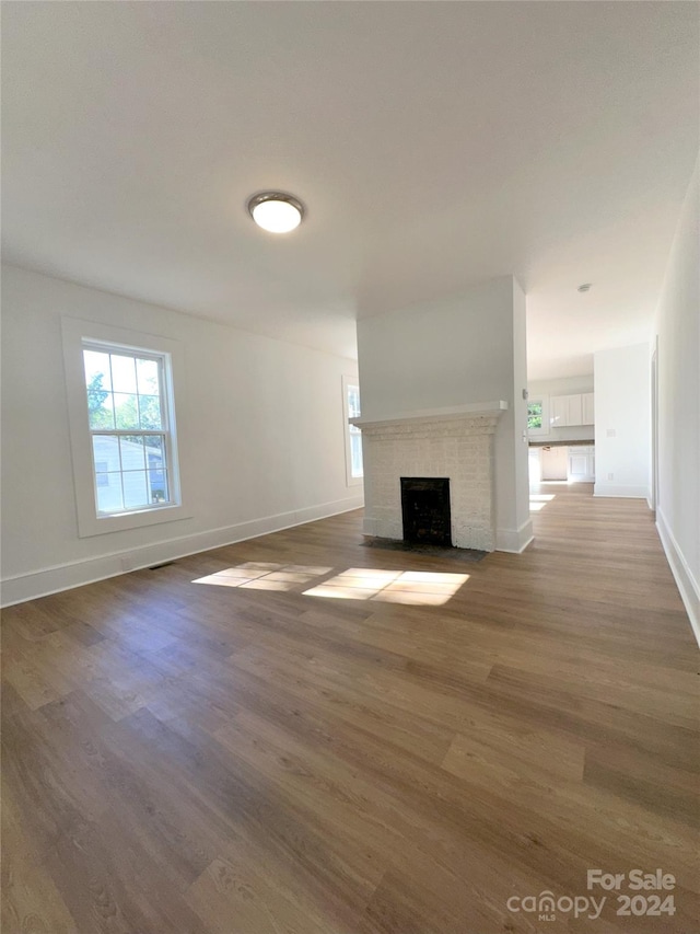 unfurnished living room with dark wood-type flooring and a fireplace