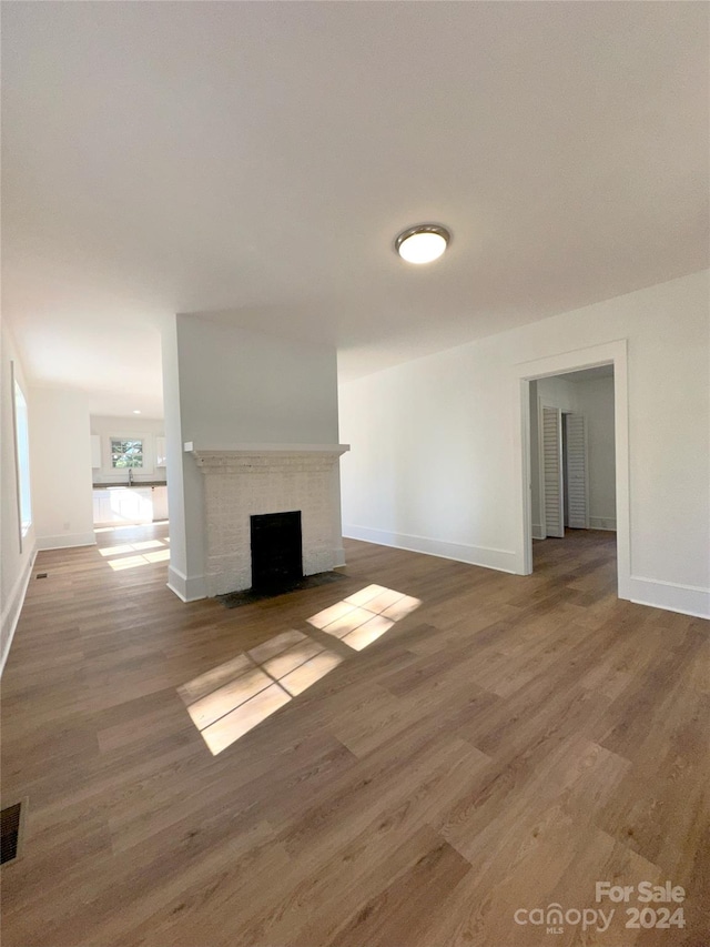 unfurnished living room with hardwood / wood-style floors and a fireplace